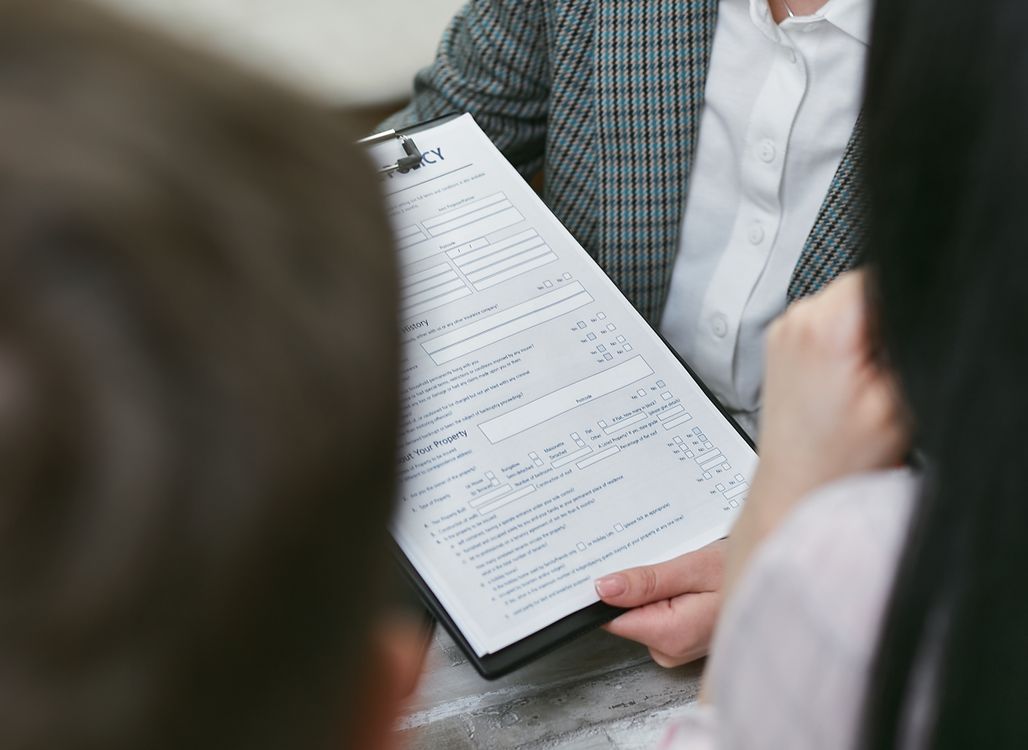 Hands reviewing financial contract and mortgage paperwork on a desk