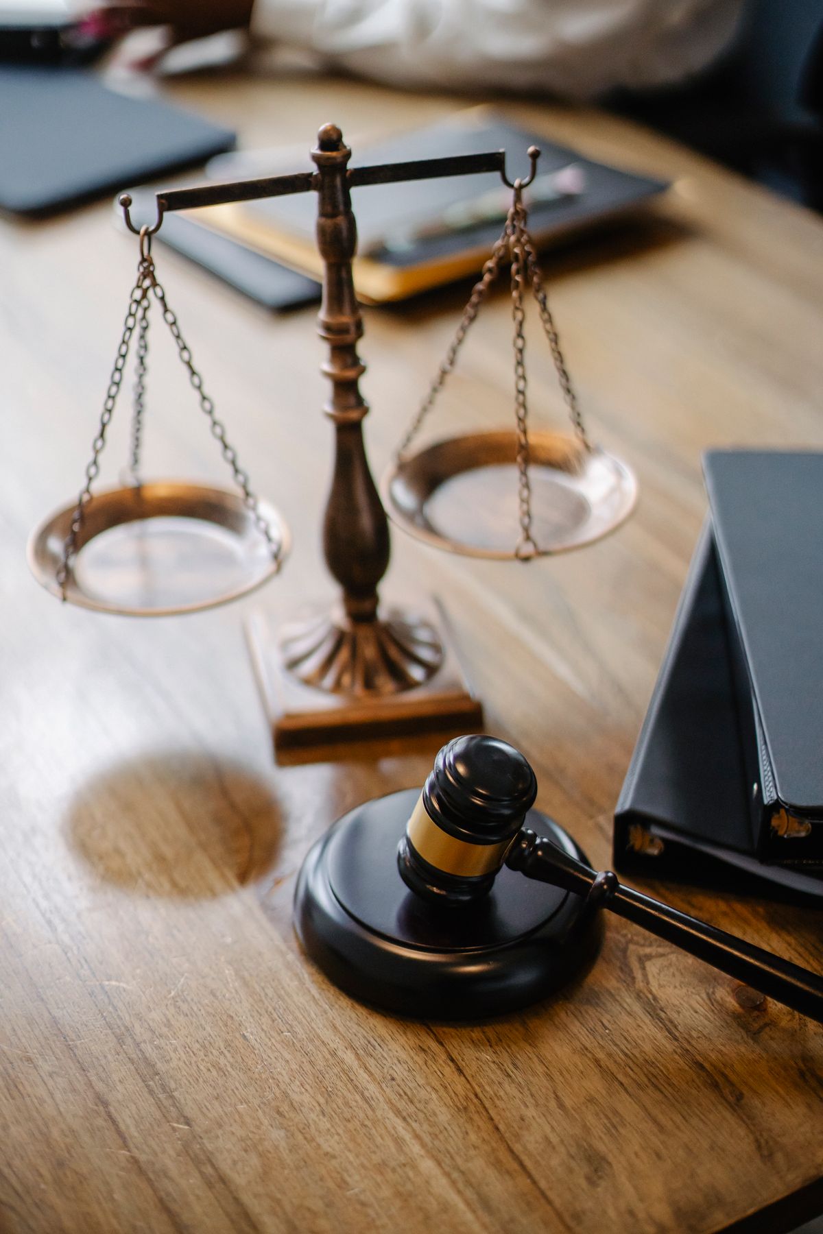 Balance scales and a gavel arranged on a wooden desk in a law office