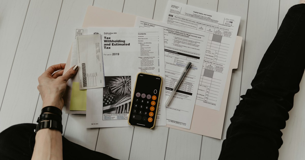 Calculator and financial documents on a desk representing tax calculations