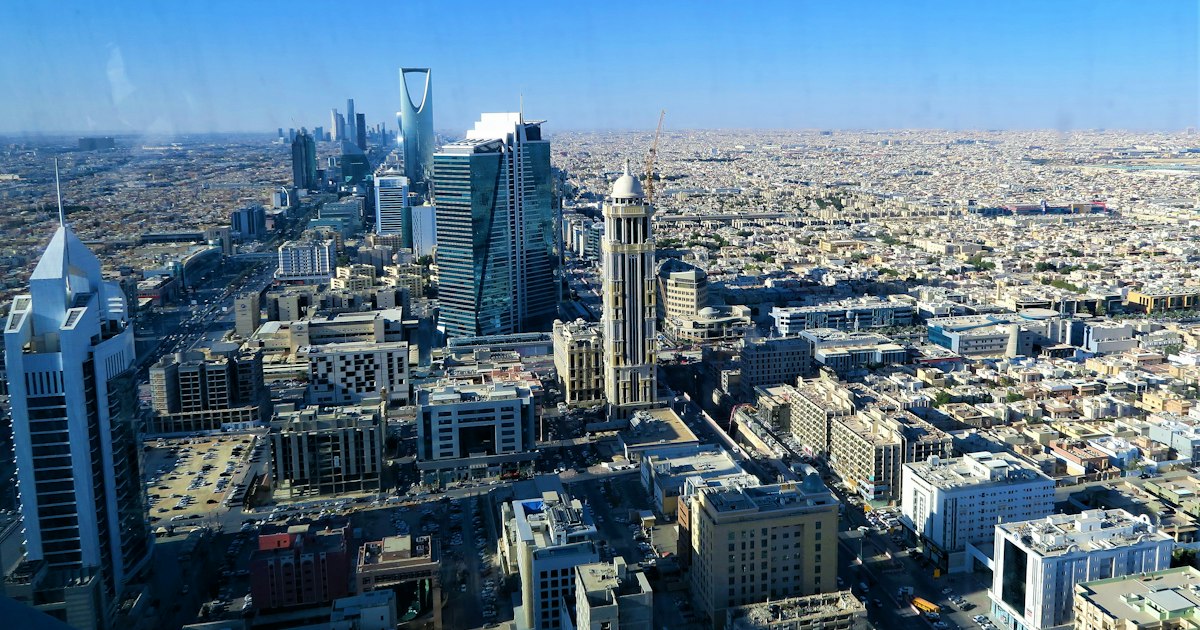 Modern Riyadh skyline with the Kingdom Centre tower against a warm sky