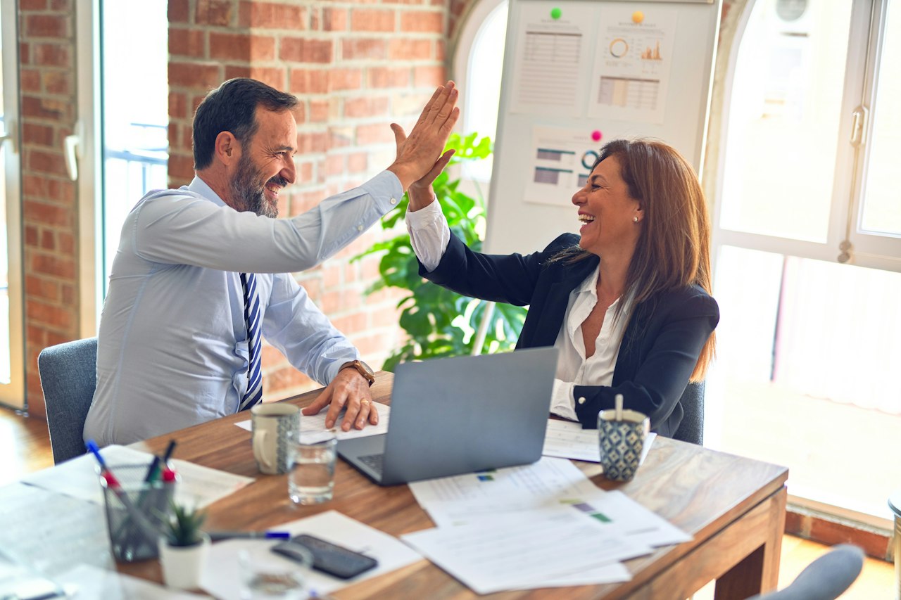Business partners reviewing a corporate agreement across a conference table